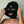 Load image into Gallery viewer, A close-up of a woman&#39;s face is shown wearing the black Extreme Rubber Hood. The hood is unzipped, and she pulls apart the outer layers to reveal the bank robber-style mask underneath. 
