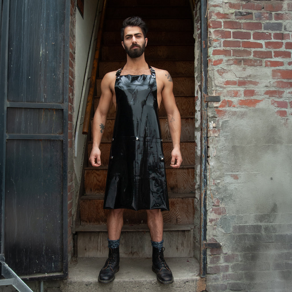 A male is shown standing at the bottom of a staircase with the Black rubber apron with opening. 