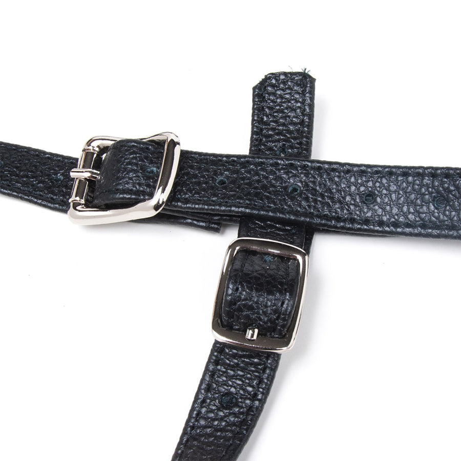 A close-up of the straps of the Terra Firma Leather Strap-on Harness is shown against a blank background. The straps are adjustable and fasten with silver buckles.