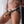 Load image into Gallery viewer, A close-up of a women&#39;s mid-body shows her wearing the black leather Terra Firma Dee Strap-on harness with a beige dildo attached. The harness has thin straps on the hips and under the butt.
