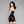 Load image into Gallery viewer, A woman with black hair and red lipstick poses in front of a grey background, facing away from the camera with her head turned over her shoulder. She wears the Latex Halter Dress in black from Syren Latex, which exposes her upper back.
