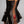 Load image into Gallery viewer, A close-up of a woman&#39;s back in the Rubber Laced Back Corset Dress is shown. Her bare back and red latex underwear with black trim are visible underneath the lacing.
