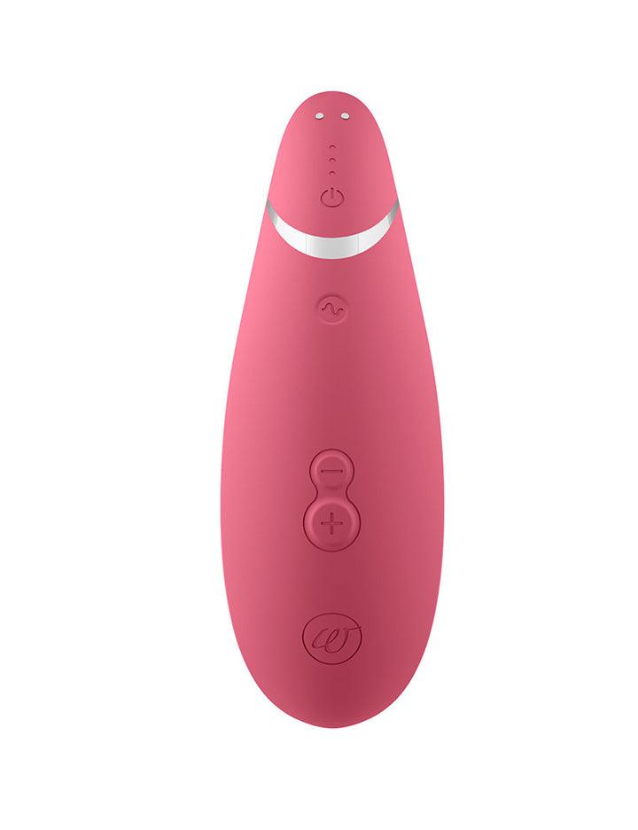 The Raspberry Womanizer Premium 2 is shown from the back against a blank background. Its three buttons and magnetic charging ports are visible.