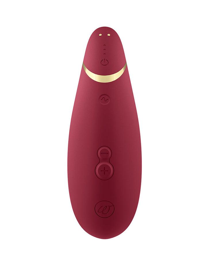 The Bordeaux Womanizer Premium 2 is shown from the back against a blank background. Its three buttons and magnetic charging ports are visible.