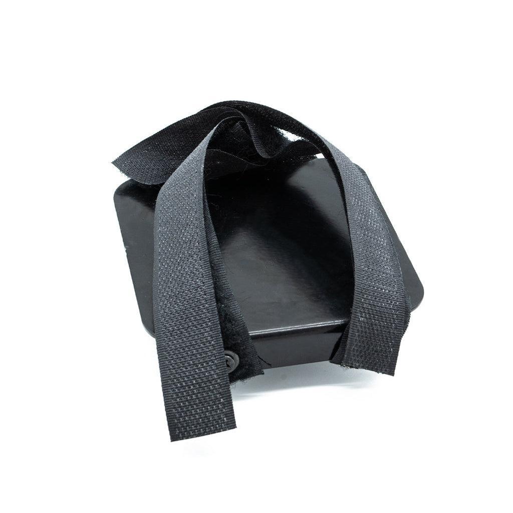 The Velcro Universal Dildo Rex Machine Adaptor is displayed against a blank background. It is a black square with velcro straps in the shape of an X.