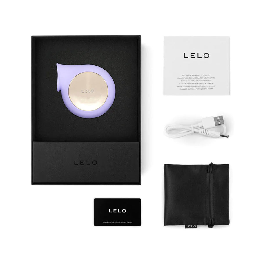 The contents for the packaging of the Lelo Sila Cruise Clitoral Massager Vibrator are shown against a blank background. Displayed are the vibrator in its box, a charger with a pouch for it, an instruction manual, and a warranty card.