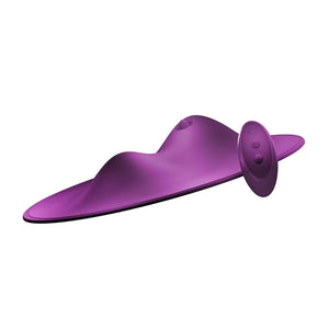 The Vibepad 2 Remote Controlled Grinding Vibrator Pad is shown against a blank background next to its remote. The toy is purple and is shaped like a disc with two prominent mounds, one small and one large. The larger mound has a tongue on it.