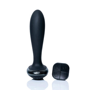 The Hot Octopuss Plex With Flex Vibrating Anal Butt Plug is shown with its remote against a blank background. The remote is square and has four buttons.