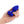 Load image into Gallery viewer, A hand is shown holding the b-Vibe Vibrating Jewel Butt Plug in Blue Sapphire against a blank background on its side, displaying the blue crystal on the base.
