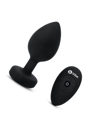 The b-Vibe Vibrating Jewel Butt Plug is shown against a blank background next to its 4 buttoned remote. The plug is a size 2XL, which is Black colored.