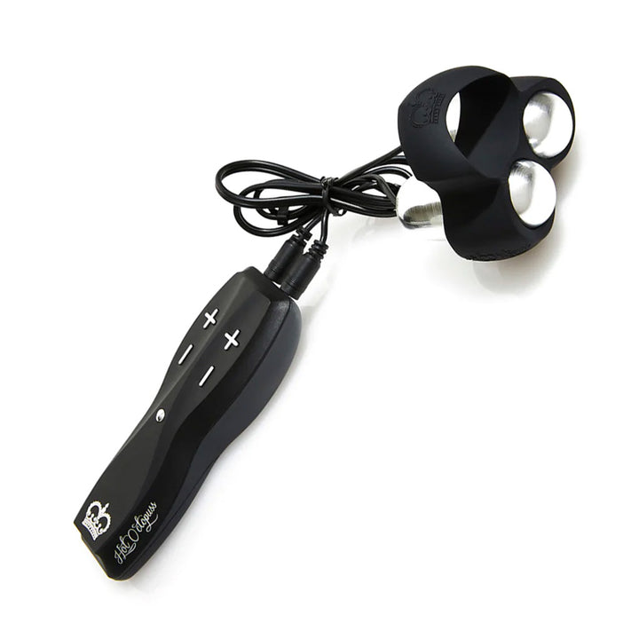 The Hot Octopuss Jett Penis Vibrator is shown against a blank background. It’s a black silicone cockring with 2 silver bullet vibrators The ring is connected by 2 wires to a remote which has a pair of + and - buttons on each side, one for each vibrator.