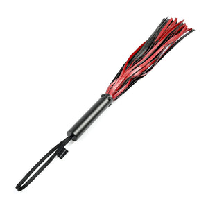 The Saffron Flogger is shown against a blank background. The falls of the flogger are red and black faux-leather. The handle of the flogger is smooth and black, and has a wrist loop attached to the end.
