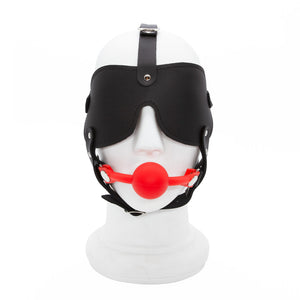 The Silicone Ball Gag And Blindfold Head Harness is displayed on a mannequin head against a blank background. The harness is made of black leather, with a blindfold and straps over the head and under the chin. 