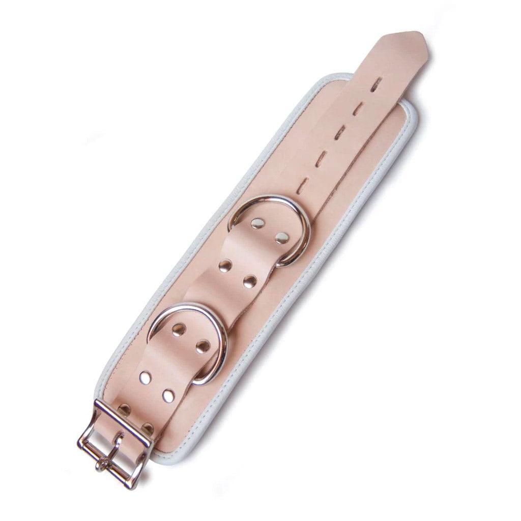 One of the Deluxe Padded Medical Leather BDSM Wrist Restraints is shown lying flat against a blank background. The cuff has an adjustable strap, two D-rings, and a lockable buckle. 