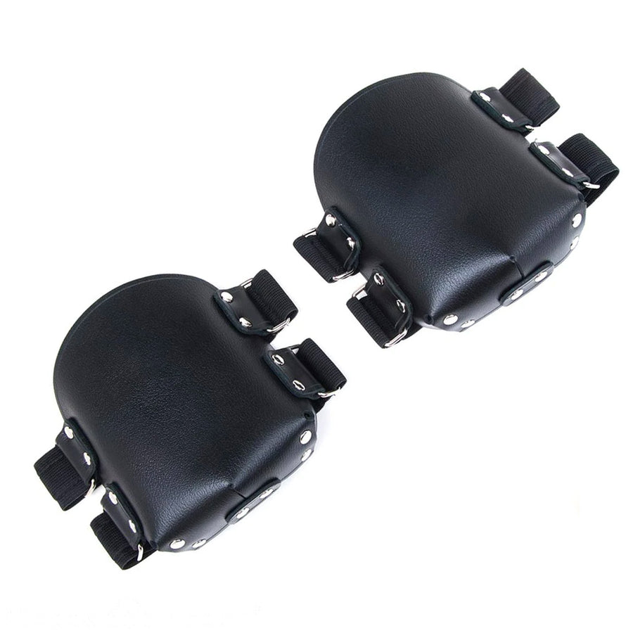 The black Premium Leather Knee Pads are shown against a blank background. They are rectangular in shape with a curved top and have metal hardware. There are two horizontal straps on each pad.