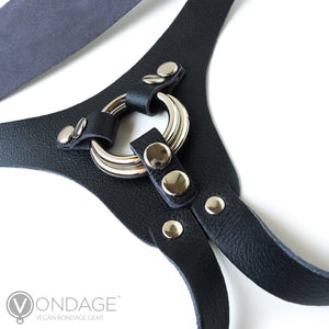 A close-up of the crotch piece of the Vondage Strapon Dildo Harness is shown against a blank background. The harness comes with two metal O-rings, which can be changed out via three small pieces of leather with snap closures.
