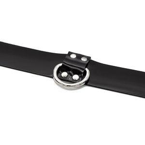 A closeup of the D-Ring of the Stockroom Black PVC Collar with a D-Ring is shown against a blank background.