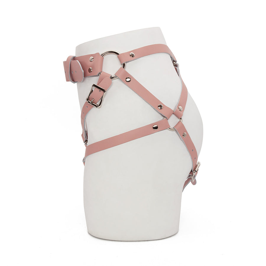 The pink leather Stockroom Stupid Cute harness is shown displayed on the lower half of a mannequin.