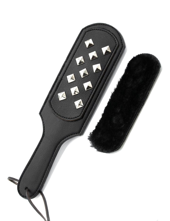 The Kinklab Panamorphic Paddle 3-In-1 Spanking Set is displayed against a blank background. The black rectangular paddle has the metal stud attachment on it, and the faux fur attachment is show next to it.