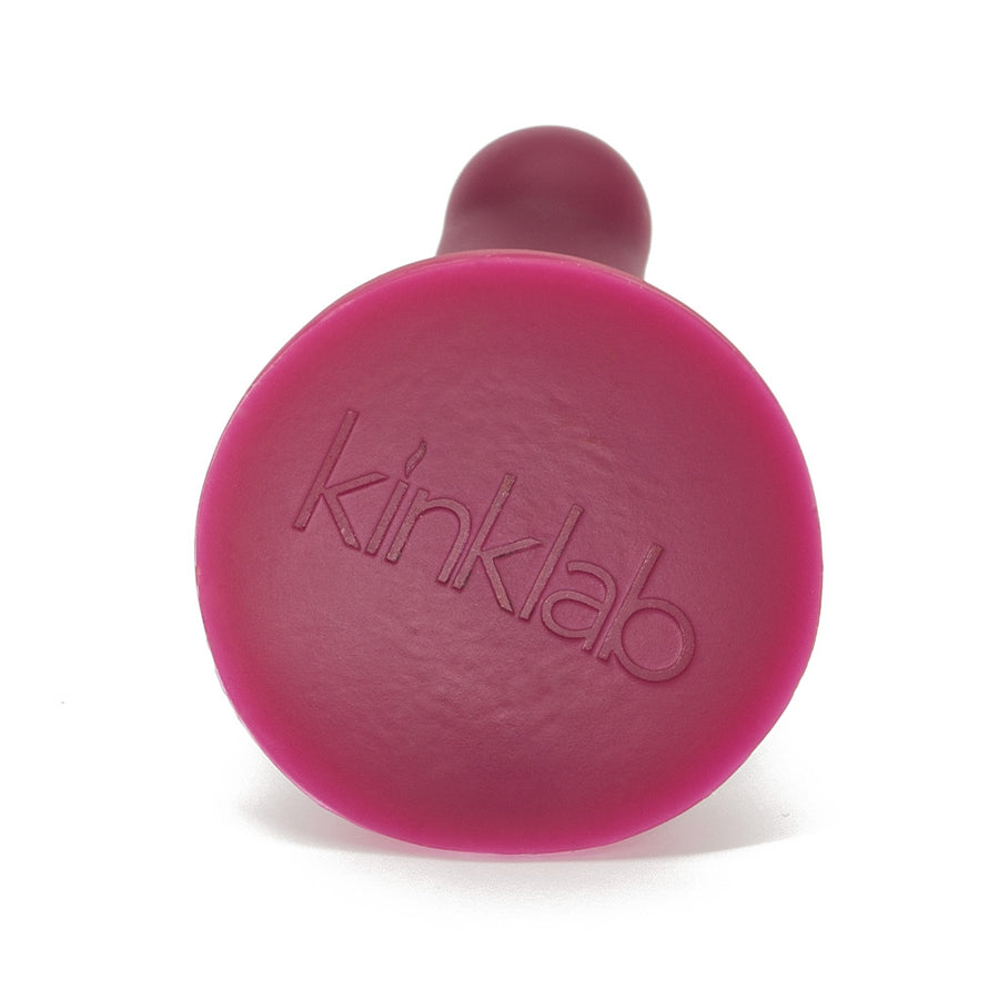 The base of the KinkLab Ebb & Flow Silicone Dildo in plum is shown against a blank background. It has the KinkLab logo embossed on it.
