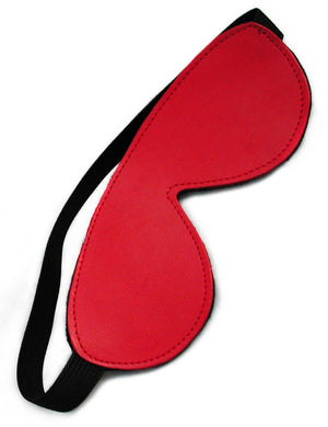 The Padded Leather Blindfold in red is shown against a blank background. The blindfold is made of red leather and has a thick black elastic strap.