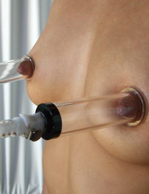 A close-up of a woman’s breasts with Nipple Suction Cylinders on her nipples is shown.