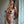 Load image into Gallery viewer, A nude woman with her hair in a ponytail leans against a white wall. Her nipples are covered by the Black Leather Pasties with Tassels, which are also black. The pasties are round, and the short tassels fall from the center.
