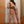 Load image into Gallery viewer, A nude woman with dark hair is shown facing a wall and bent over. She holds the black Round Leather Paddle and reaches around to spank herself.
