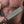 Load image into Gallery viewer, A close-up of a nude man’s hairy chest is shown. He holds the Black Leather Fraternity Paddle in his fist in front of his chest.
