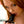 Load image into Gallery viewer, A close-up of a red-haired woman shows her holding the black Tantus Silicone Fantasy Penis Gag up to her open mouth.
