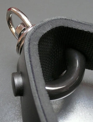 A close-up of the curved bit gag of the Half Moon Bit Gag By Scott Paul Designs is shown on a grey table.