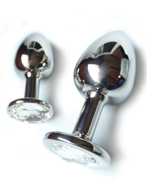 Two Julian Snelling Rosebuds Jeweled Anal Plugs, one medium and one large, are displayed against a blank background. The plug is made of silver metal and is tapered with a thin neck and wide base. The base has a clear Swarovski Crystal covering it.