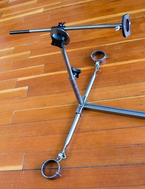 The lower half of the Stockroom Stockade, positioned on a wooden floor, is shown. There are twistable handles to adjust the depth of the fucking rod.