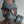 Load image into Gallery viewer, A close-up of a man with buzzed hair standing in front of a grey wall wearing the grey Finnish Military Gas Mask with the side-mounting filter attached. 
