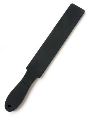 The Wham Bam Tantus Paddle is displayed against a blank background. The paddle is made of matte black silicone and has a narrow, rectangular impact point with a handle with a rounded end. 