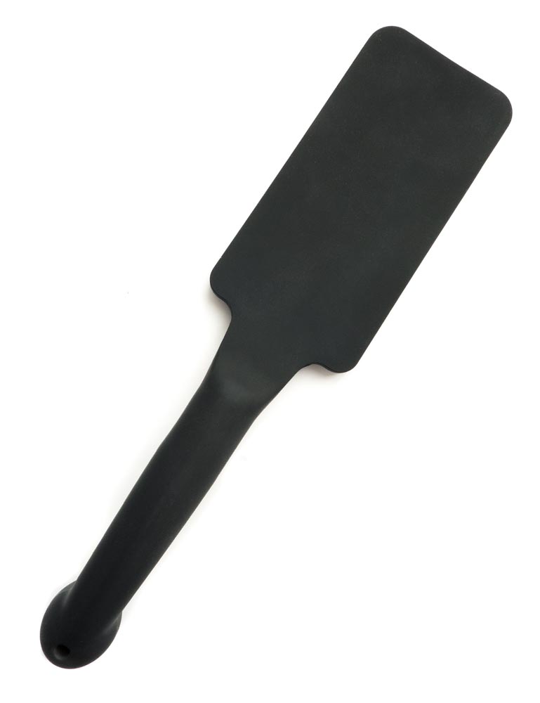 The Tantus Plunge Paddle is displayed against a blank background. The paddle is rectangle-shaped and has a cylindrical handle. It is made of matte black silicone.