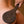 Load image into Gallery viewer, A close-up of a woman’s bare butt is shown with somebody holding the Ebony Pine Peony Engraved Wooden Spanking Paddle against it.
