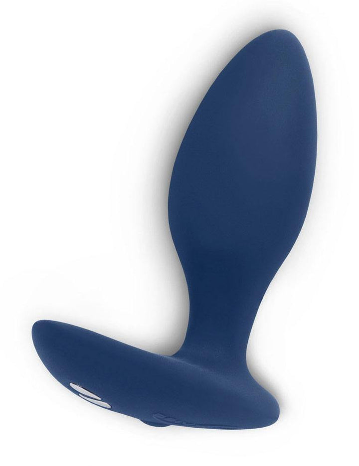 The We-Vibe Ditto Vibrating Butt Plug is shown against a blank background. The plug is made of matte blue silicone and is tapered with a thinner neck and wide base. The base extends to one side for perineal stimulation. 