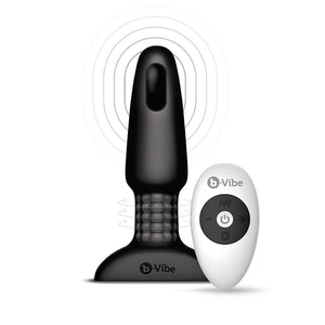 An illustration showing the interior of the B-Vibe Rimming Butt Plug 2 is shown with its remote against a blank background. At the tip is a small black oval with rings radiating out of it. At the base are a cluster of beads with horizontal arrows over them.