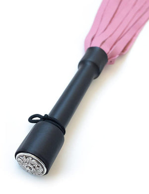 A close-up of the Pink Devil Leather Flogger By Dragontailz handle is displayed against a blank background, showing the silver ornamental cap on the end of the handle. 