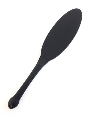 The matte black Tantus Gen Mini Silicone Paddle is displayed against a blank background. The top of the paddle is thin and oval in shape, and the handle is cylindrical with a bulbous bottom.