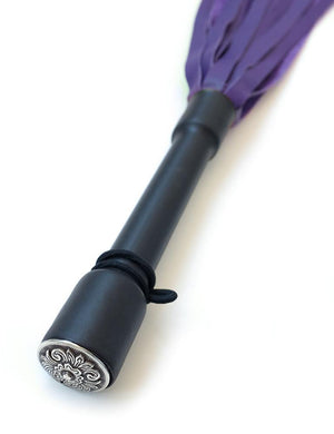 A close-up of the Purple Devil Leather Flogger By Dragontailz handle is displayed against a blank background, showing the silver ornamental cap on the end of the handle. 