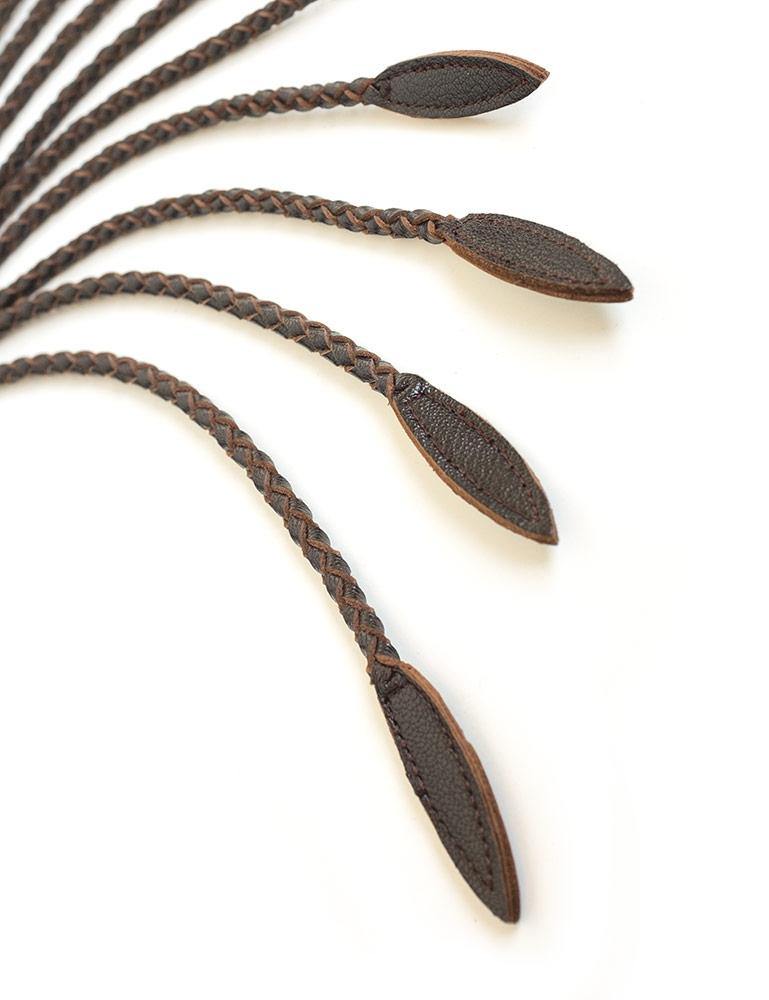 A close-up of the ends of the falls of the Brown Leather Braided Whip are displayed against a blank background. 