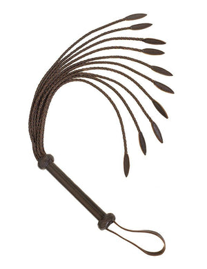 The Brown Leather Braided Whip is shown against a blank background. The falls of the whip are made of thin pieces of leather braided together with a wider tear-drop shape at the end. The handle is made of brown leather and has a wrist loop at the base.