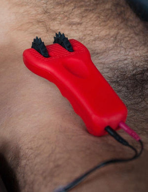 A close-up of a man’s torso shows the Electrastim Silicone Fusion Infinity Pinwheel resting on it.