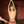 Load image into Gallery viewer, A nude woman with short blonde hair faces away from the camera, standing with her arms raised and leaning against a wooden pole. Somebody holds the Saffron Loop paddle against her butt.
