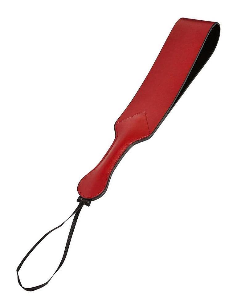 The Saffron Loop paddle, made of red faux leather, is displayed against a blank background. The paddle is a piece of folded-over leather attached to a handle, creating a loop, with a wrist loop at the end.