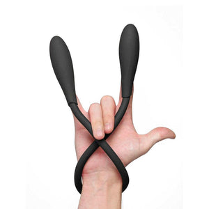 A woman’s hand is shown with her pinky, pointer finger, and thumb outstretched and her two middle fingers curled down. The Picobong Transformer Silicone Vibrator is looped around her wrist with the ends covering her pinky finger and her pointer finger.