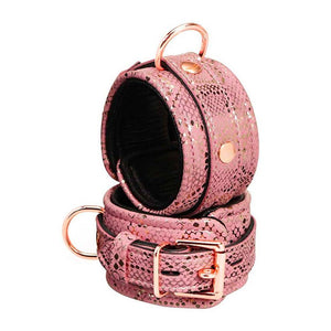 A pair of Rose Gold Snake Wrist Cuffs are shown stacked on top of each other against a blank background. The lining of the cuffs is black.