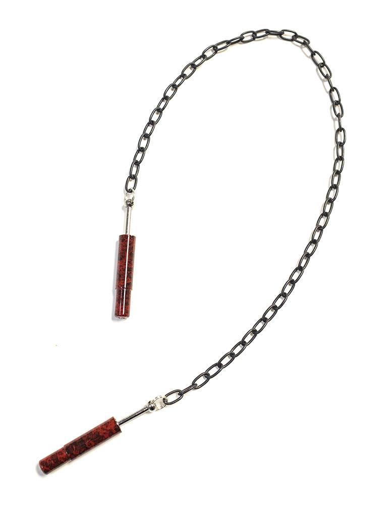 The red Extreme Talon Nipple Clamps are shown against a blank background. The clamps are dark red cylinders with the edges retracted into them. They are attached by a silver chain link. 